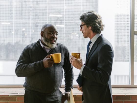 Deux hommes d’affaires mûrs échangent autour d’un café. Photographie d’illustration.