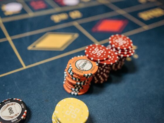 Jetons de casino empilés sur une table de roulette bleue.